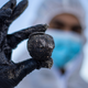 An Israeli soldier wearing a full protective suit holds a piece of tar from an oil spill in the Mediterranean Sea during a cleanup operation.